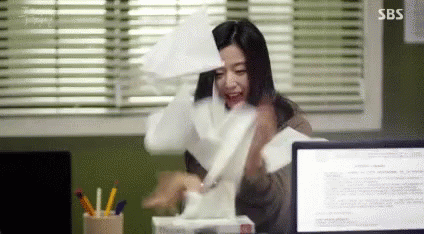 A Woman Is Sitting At A Desk With A Box Of Tissues In Front Of A Computer . GIF