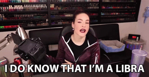 A Woman Is Sitting At A Desk With A Camera And Says I Do Know That I 'M A Libra GIF