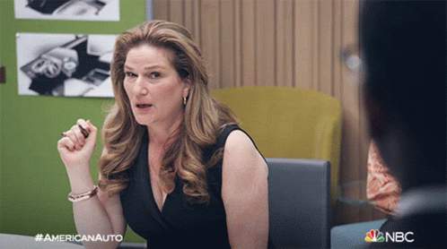 a woman is sitting at a desk with a nbc logo on the bottom