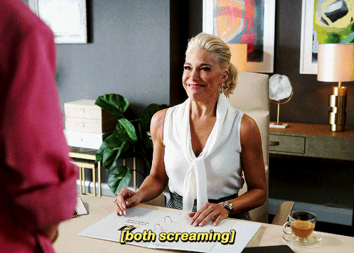 A Woman Is Sitting At A Desk With The Words Both Screaming Written Above Her GIF