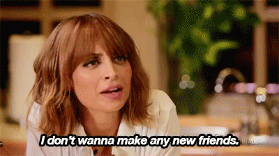 A Woman Is Sitting At A Table And Saying `` I Don 'T Wanna Make Any New Friends . '' GIF