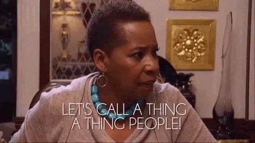 A Woman Is Sitting At A Table And Saying Let 'S Call A Thing A Thing People GIF