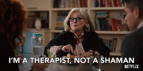 A Woman Is Sitting At A Table And Says I 'M A Therapist Not A Shaman GIF