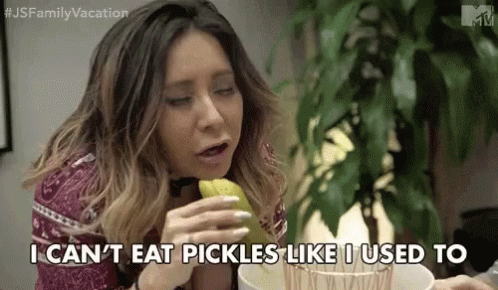 A Woman Is Sitting At A Table Eating Pickles And Saying `` I Can 'T Eat Pickles Like I Used To '' GIF