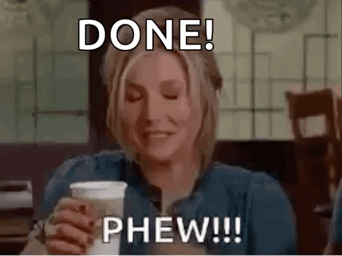 A Woman Is Sitting At A Table Holding A Cup Of Coffee And Making A Funny Face . GIF