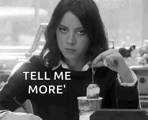 A Woman Is Sitting At A Table Holding A Tea Bag And A Cup Of Coffee . GIF
