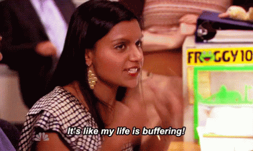 A Woman Is Sitting At A Table In Front Of A Machine That Says `` It 'S Like My Life Is Buffering '' . GIF
