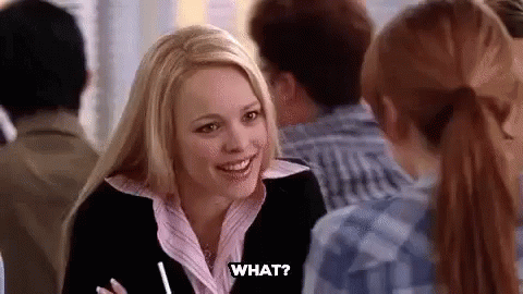 A Woman Is Sitting At A Table Talking To A Group Of People And Smiling . GIF