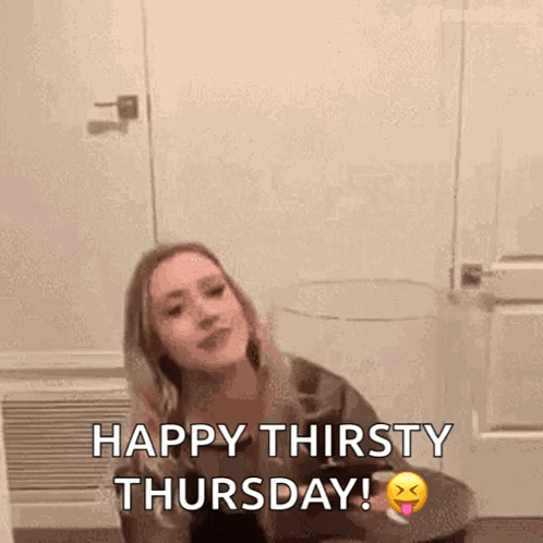 A Woman Is Sitting At A Table With A Glass Of Wine And The Words Happy Thirsty Thursday . GIF
