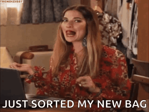 A Woman Is Sitting At A Table With A Laptop And Saying `` Just Sorted My New Bag '' GIF