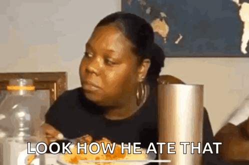 A Woman Is Sitting At A Table With A Plate Of Food And A Bottle Of Water . GIF