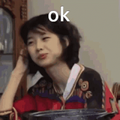 A Woman Is Sitting At A Table With A Pot In Her Hand And Making A Face . GIF