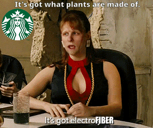 A Woman Is Sitting At A Table With A Starbucks Logo In The Background And Says It 'S Got What Plants Are Made Of GIF