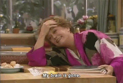 A Woman Is Sitting At A Table With Her Hand On Her Forehead And Saying `` My Brain Is Gone . '' GIF