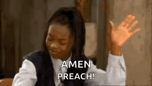 A Woman Is Sitting At A Table With Her Hands In The Air . GIF