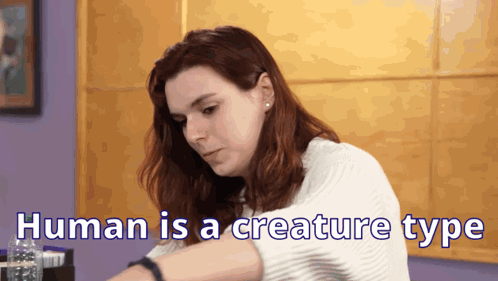 A Woman Is Sitting At A Table With The Words Human Is A Creature Type Written On The Bottom GIF