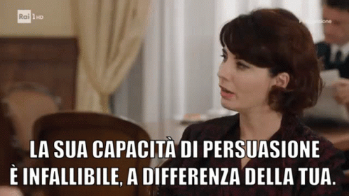 A Woman Is Sitting At A Table With The Words La Sua Capacita Di Persuasione E Infallibile GIF