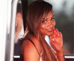 A Woman Is Sitting In A Car Looking Out The Window . GIF