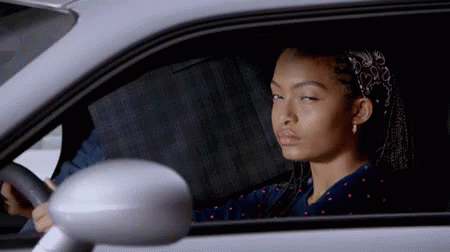 A Woman Is Sitting In A Car With Her Eyes Closed GIF