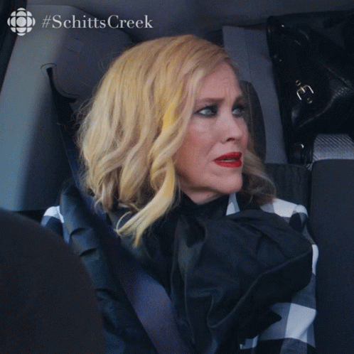 A Woman Is Sitting In A Car With The Words What Is It GIF
