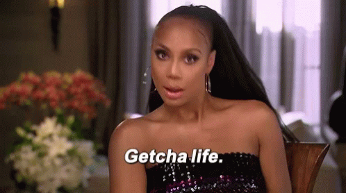 A Woman Is Sitting In A Chair And Saying Getcha Life GIF