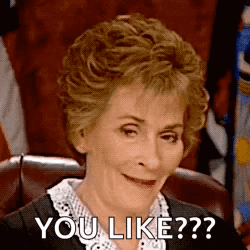 A Woman Is Sitting In A Chair And Smiling While Saying `` You Like ? '' . GIF