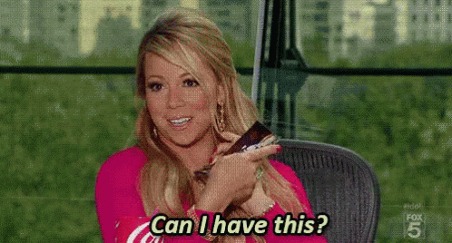 A Woman Is Sitting In A Chair Holding A Remote Control And Asking , Can I Have This ? GIF