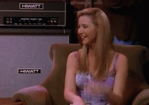 A Woman Is Sitting In A Chair In Front Of A Hiwatt Amplifier . GIF