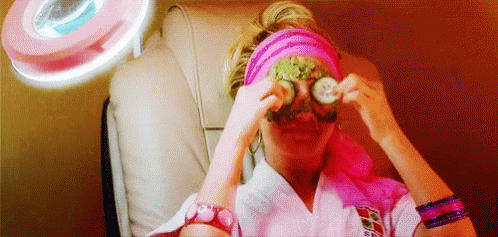 A Woman Is Sitting In A Chair With A Mask On Her Eyes . GIF