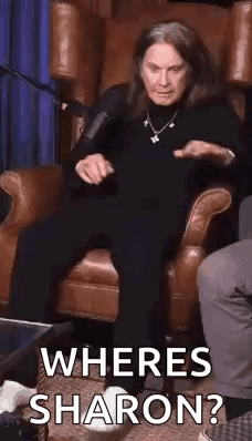 A Woman Is Sitting In A Chair With A Microphone And Asking Where Is Sharon ? GIF