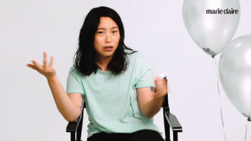 A Woman Is Sitting In A Chair With Balloons In The Background And The Word Marie Claire Is On The Balloon GIF