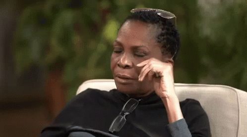 A Woman Is Sitting In A Chair With Her Eyes Closed And The Word Lord Written On The Screen . GIF