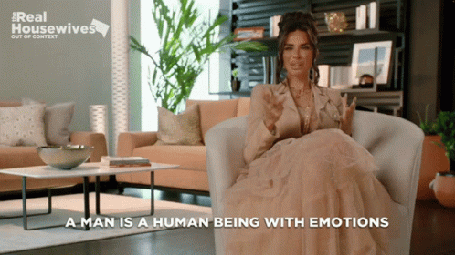 A Woman Is Sitting In A Chair With The Words " A Man Is A Human Being With Emotions " GIF