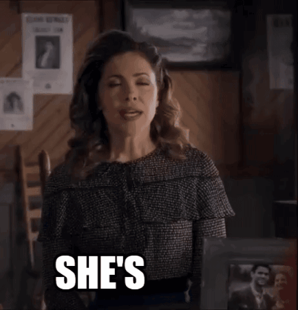 A Woman Is Sitting In A Chair With The Words She 'S Quirky Written On Her Face . GIF