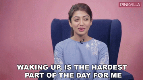 A Woman Is Sitting In A Chair With The Words Waking Up Is The Hardest Part Of The Day For Me Written Below Her GIF