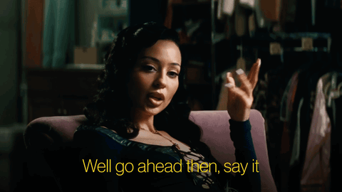 A Woman Is Sitting In A Chair With The Words Well Go Ahead Then Say It GIF