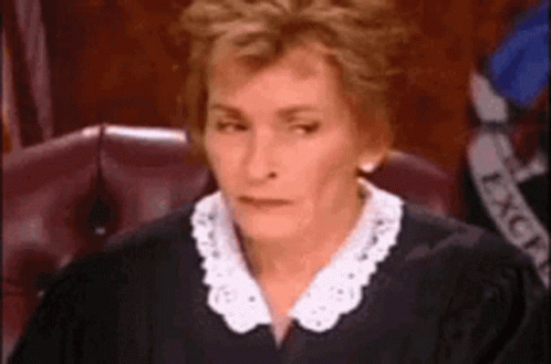 A Woman Is Sitting In A Courtroom Wearing A Judge 'S Robe And A White Collar . GIF