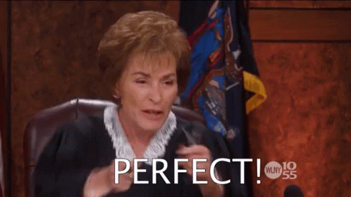 A Woman Is Sitting In A Courtroom With Her Hands In The Air And The Words Perfect Above Her GIF