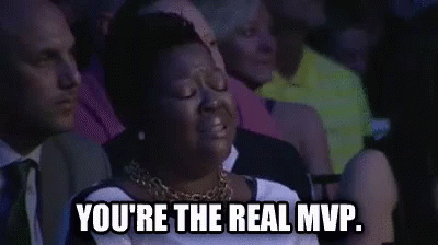 A Woman Is Sitting In A Crowd Of People And Crying . GIF