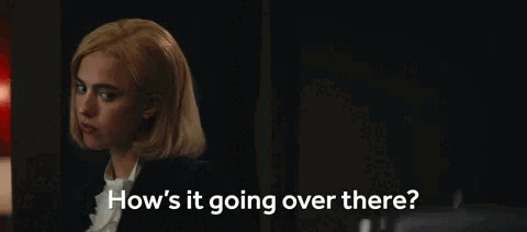 A Woman Is Sitting In A Dark Room Talking To Someone . GIF