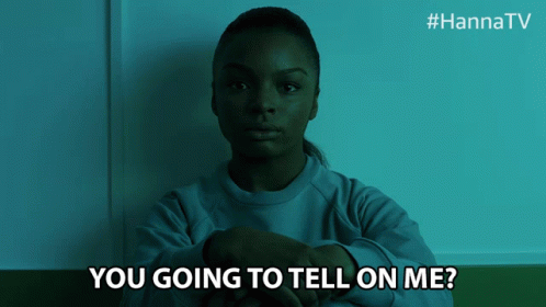 A Woman Is Sitting In A Dark Room With The Words " You Going To Tell On Me " Below Her GIF