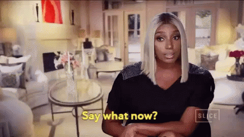 A Woman Is Sitting In A Living Room And Saying " Say What Now " . GIF