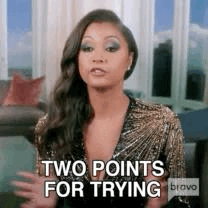 A Woman Is Sitting In A Living Room With Her Arms Outstretched And Says `` Two Points For Trying '' . GIF