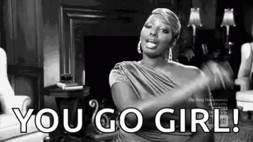 A Woman Is Sitting In A Living Room With Her Arms Outstretched And Says `` You Go Girl '' . GIF