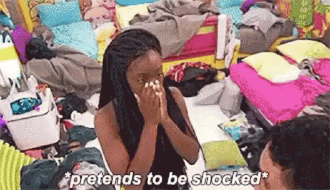 A Woman Is Sitting In A Messy Room And Covering Her Face With Her Hands While A Man Looks On . GIF