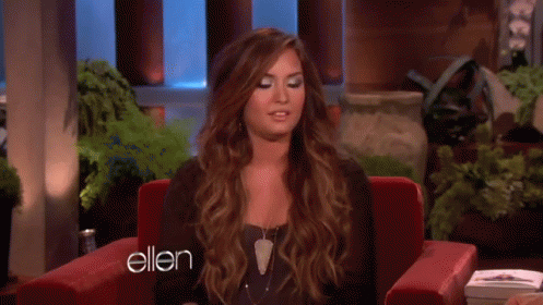 A Woman Is Sitting In A Red Chair With The Word Ellen On The Bottom GIF