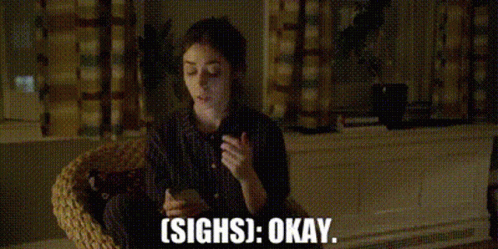 A Woman Is Sitting In A Wicker Chair Holding A Cell Phone And Saying `` Sighs Okay '' . GIF