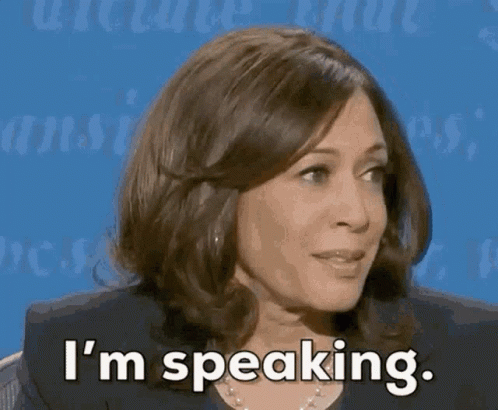 A Woman Is Sitting In Front Of A Blue Background And Says I 'M Speaking . GIF