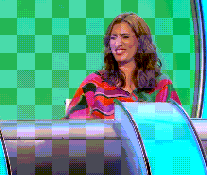 A Woman Is Sitting In Front Of A Green Screen . GIF