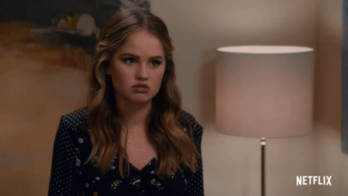 A Woman Is Sitting In Front Of A Lamp And A Netflix Logo GIF